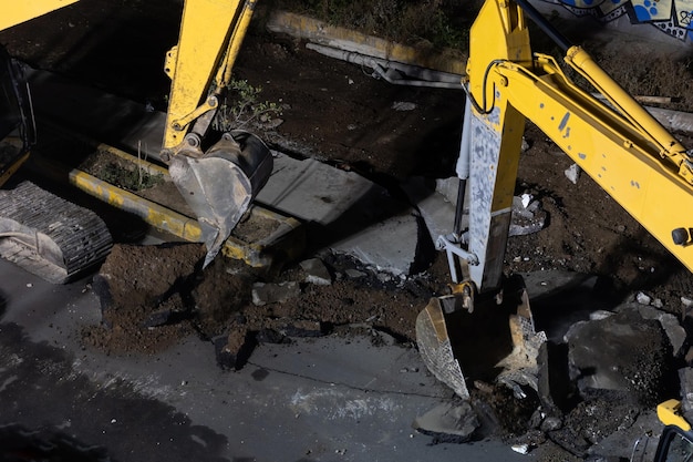 Escavadora amarela trabalhando à noite na rua