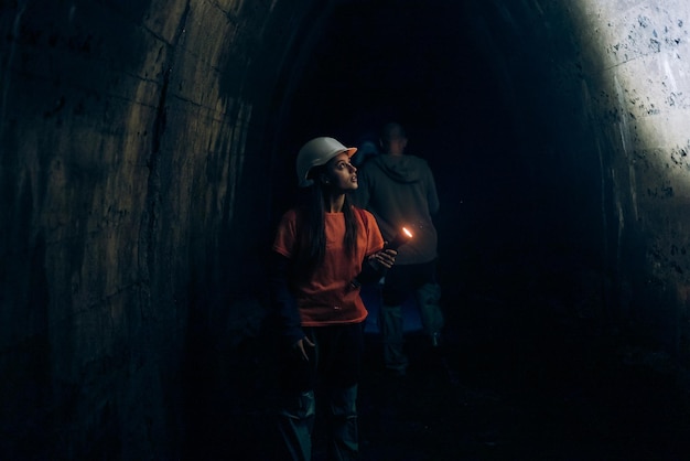 Escavadora feminina com lanterna explora o túnel