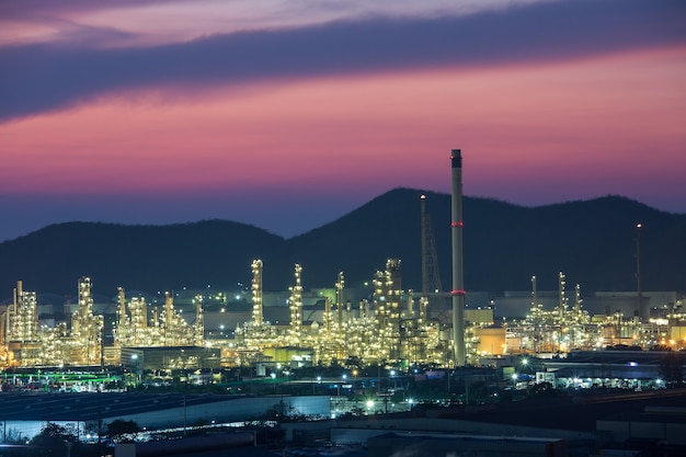 Escena del atardecer de refinería de detalle de una planta industrial química pesada con refinería de tuberías en penumbra