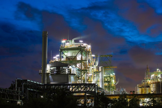 Escena azul de la nube de sol crepuscular de la planta de refinería de petróleo y aceite de columna de torre de la industria petroquímica en el crepúsculo