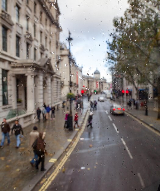 Escena de la calle de la ciudad de Londres a través de la ventana del autobús de dos pisos con gotas de lluvia