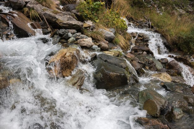 Escena de la cascada de la opinión del primer en las montañas, parque nacional de Dombay, Cáucaso, Rusia. Paisaje de verano, clima soleado y día soleado.