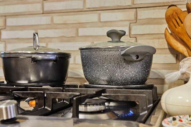 Escena de cocina ocupada con tapas de ollas y estufa de gas cocinando comida en casa