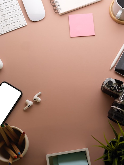 escena creativa, espacio de trabajo plano con teléfono inteligente, artículos de papelería, accesorios y espacio de copia, trazado de recorte