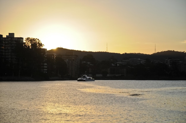 Escena dramática al atardecer con ferry de transporte público en un río ancho en Brisbane, Australia