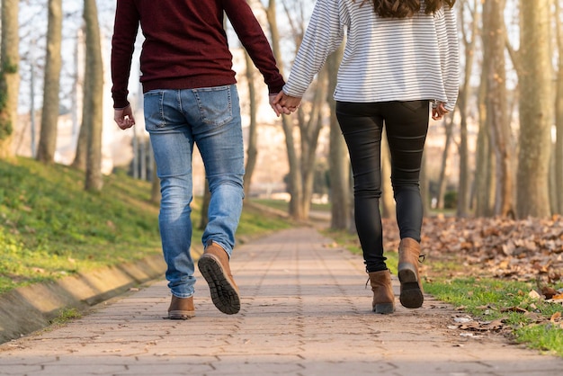 Foto escena feliz y romántica con una joven pareja heterosexual caminando y abrazándose en un parque el día de san valentín