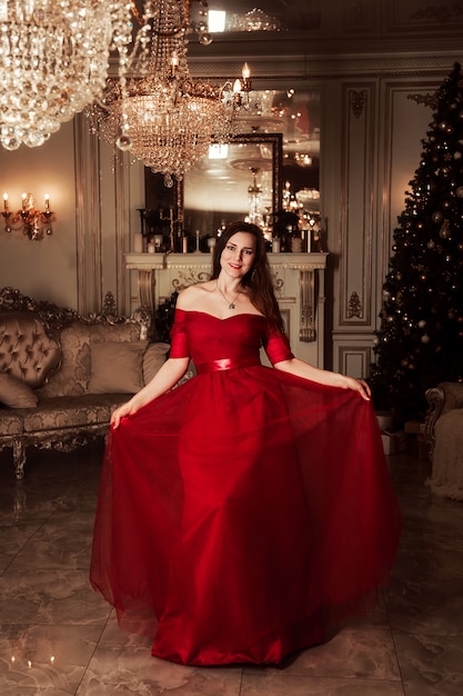 Escena de la fiesta de Navidad, mujer en un hermoso vestido rojo, concepto de moda