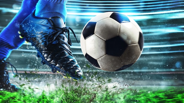 Escena de fútbol en el partido de la noche con cerca de un zapato de fútbol golpeando la pelota con poder