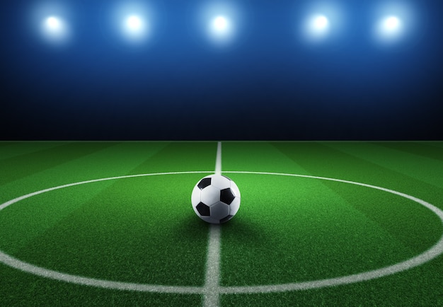 Escena de fútbol en partido nocturno con balón de fútbol en el mediocampo.
