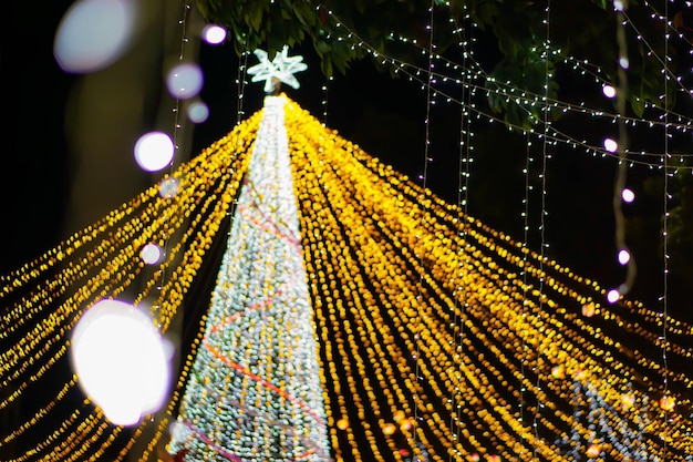 Escena de iluminación borrosa y bokeh del árbol de Navidad en el fondo nocturno