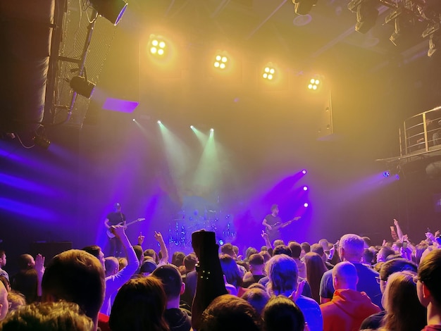 Foto escena iluminada de un concierto de rock hay muchos espectadores en la sala