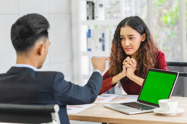 Escena del jefe furioso regañando a la empresaria asiática joven pareja en traje formal por punto a su cara