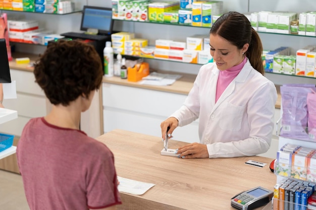 Escena con un joven farmacéutico cortando el código de barras de un medicamento recetado en una farmacia