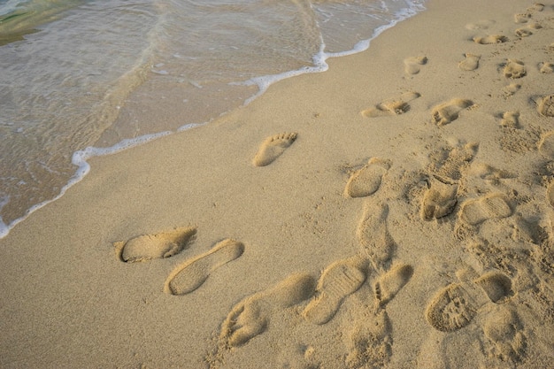 Escena mediterránea, orilla del mar Mediterráneo con huellas descalzas de personas en verano