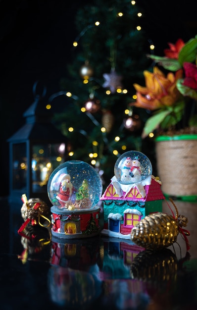 Escena de Navidad con árbol, luces y globo de nieve. Enfoque selectivo