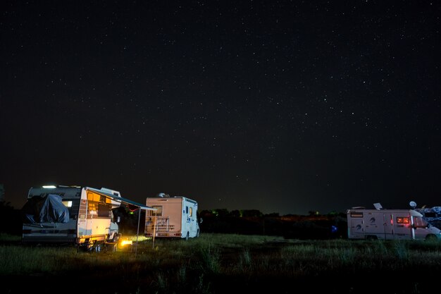 Escena nocturna con autocaravanas camper en camping