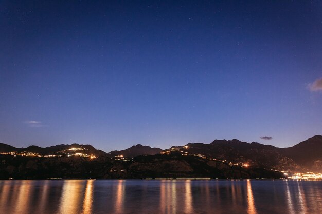 Escena nocturna en lago di garda Lake rocks and village