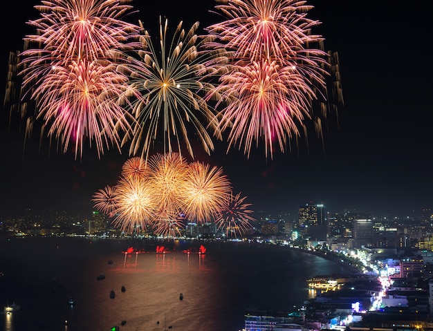 Escena nocturna multicolores de los fuegos artificiales, paisaje urbano borroso de la foto pattaya