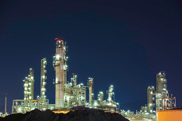 Escena nocturna de la planta de refinería de petróleo y la columna de la torre de la construcción del sitio de la industria petroquímica