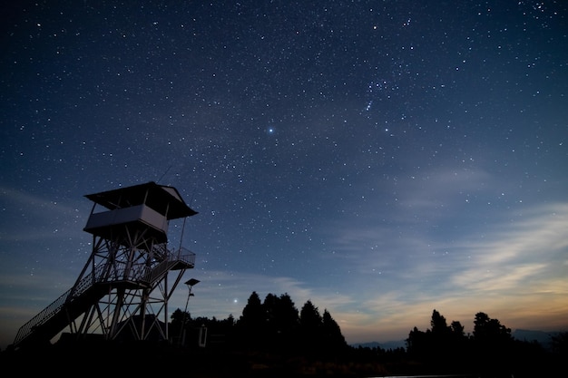 Una escena nocturna con una torre de salvavidas y estrellas en el cielo.