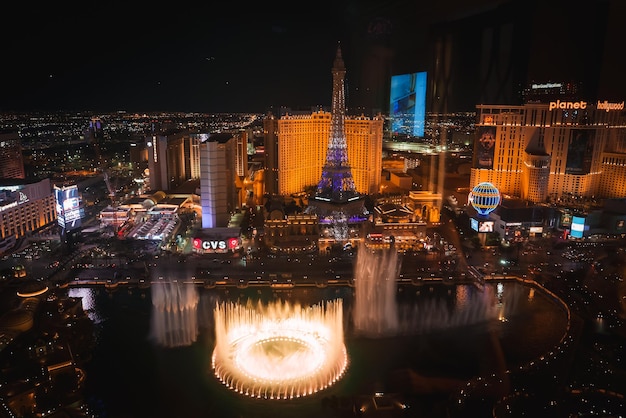 Foto escena noturna vibrante com fontes de bellagio e torre eiffel em las vegas