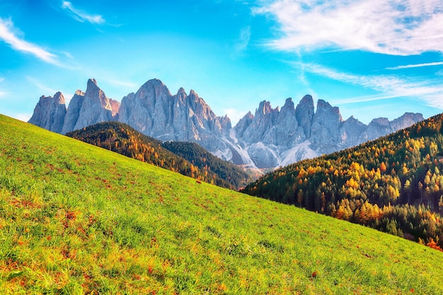 Foto escena otoñal de santa magdalena famosa italia dolomitas pueblo vista frente a las rocas de montaña geisler o odle dolomites group