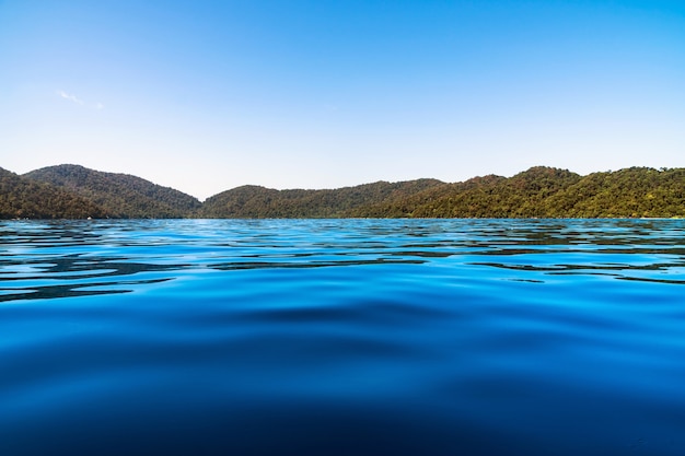 Foto escena del paisaje del mar azul y cielo con isla que tienen montaña