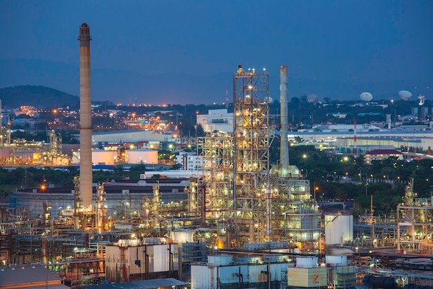 Escena de la planta de refinería y la columna de la torre de la puesta del sol de la tarde Industria de la petroquímica en el sitio de construcción.