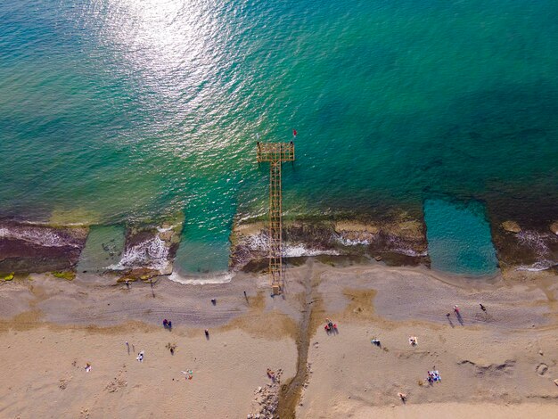 Una escena de playa con un muelle al fondo.