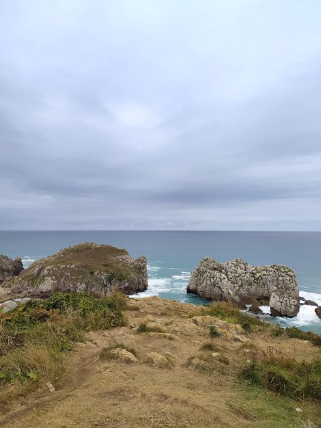 Foto una escena de playa con rocas y el océano en el fondo