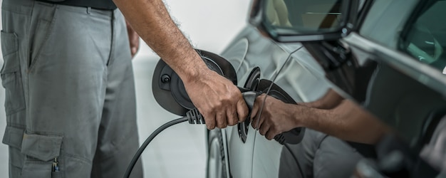 Escena de portada y portada de la mano de primer plano de la carga técnica del vehículo en mantenimiento eléctrico