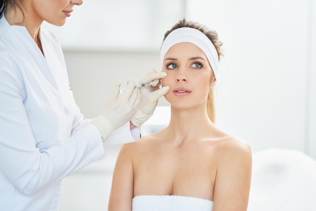 Una escena de tratamientos de cosmetología médica inyección de botox.