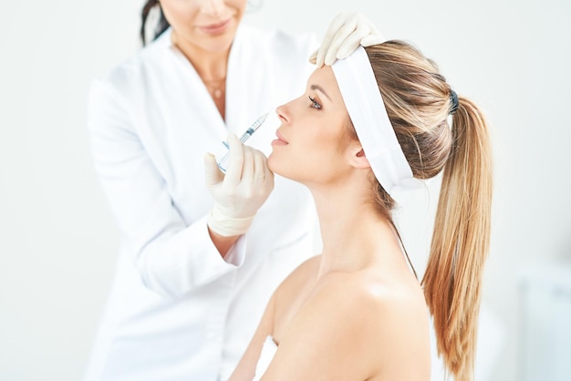 Una escena de tratamientos de cosmetología médica inyección de botox.