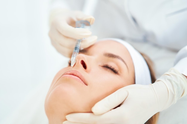 Una escena de tratamientos de cosmetología médica inyección de botox.