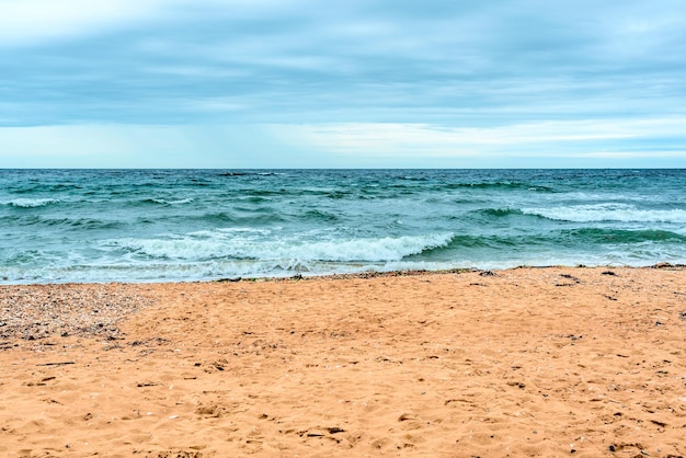 Escena de verano con espuma blanca de agua de mar azul y arena amarilla con enfoque selectivo Concepto de vacaciones o vacaciones Fondo de naturaleza con espacio de copia