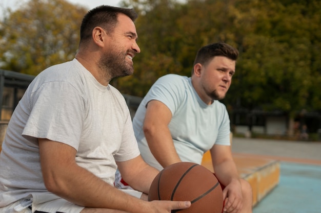 Foto escenas auténticas de hombres de talla grande jugando al baloncesto