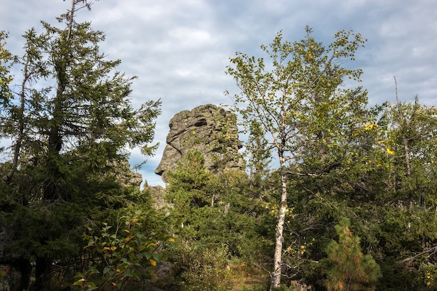 Escenas de montañas de primer plano en el parque nacional Kachkanar, Rusia, Europa. Clima nublado, cielo dramático de color azul, árboles verdes lejanos. Colorido día de verano