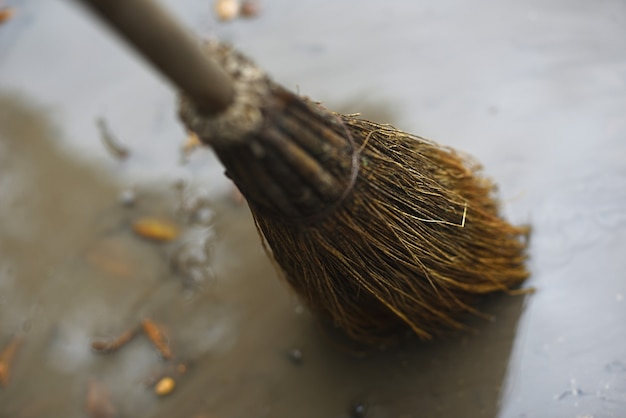 Escoba de paja barriendo un charco de lluvia