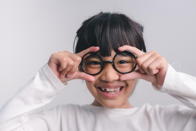 Escola de educação e conceito de visão sorrindo menina bonitinha em óculos escuros