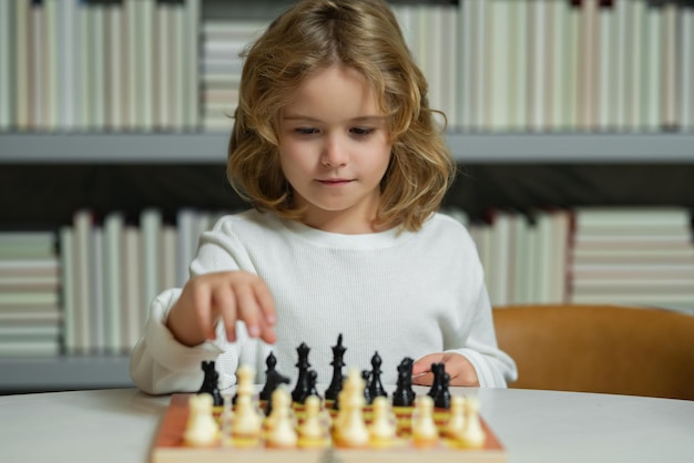 Escola de xadrez Xadrez infantil concentrado Criança jogando jogo de tabuleiro na sala de aula