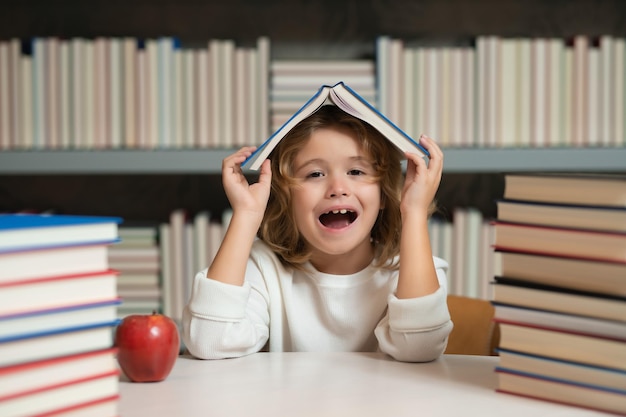 Escola e conceito de educação menino de escola lendo livro na biblioteca desenvolvimento infantil aprende a ler aluno