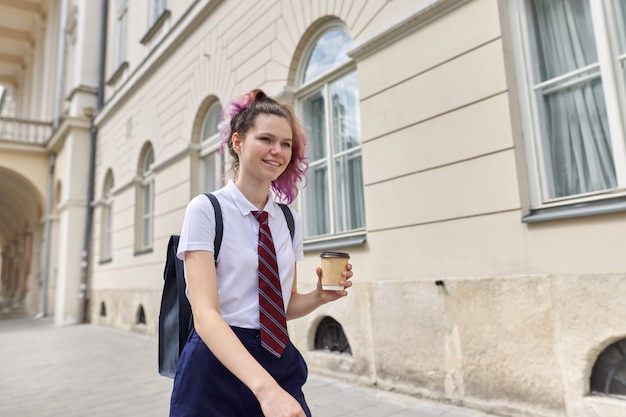Escola menina andando com mochila e café