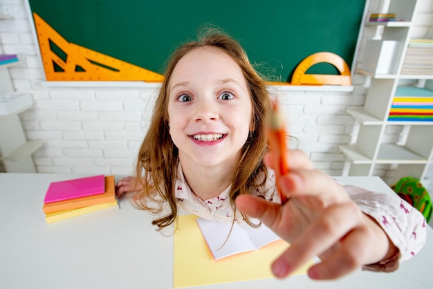 Escola pré-escolar engraçada com óculos divertidos na escola. Garota de aluno feliz inteligente.