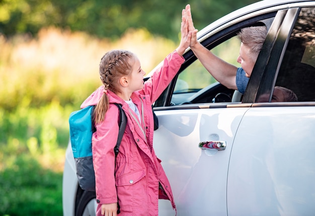 Escolar dando cinco al padre en coche