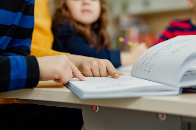 Escolares en la biblioteca leyendo libros, haciendo deberes, preparando un proyecto escolar para las lecciones