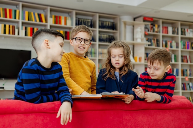 Escolares en la biblioteca leyendo libros, haciendo deberes, preparándose para las lecciones