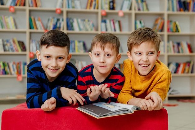 Escolares en la biblioteca leyendo libros, haciendo deberes, preparándose para las lecciones