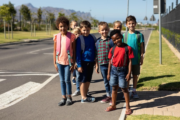 Escolares esperando en un paso de peatones para cruzar la calle