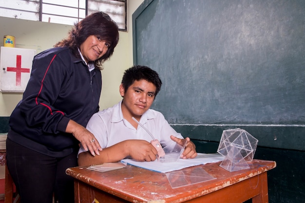 Escolares peruanos sudamericanos posando solos y con sus maestros realizando tareas