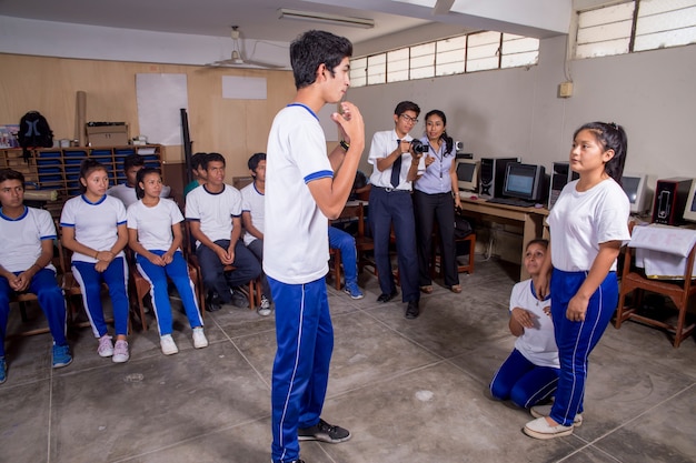 Escolares peruanos sudamericanos posando solos y con sus maestros realizando tareas